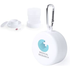 A foldable cup in white with a carabiner. The cup is accompanied by a lid and has a logo on it.