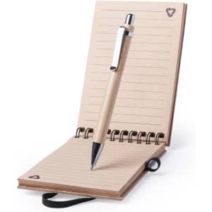 A bamboo notebook with a spiral binding and a black pen, featuring tan pages and a logo on the cover.