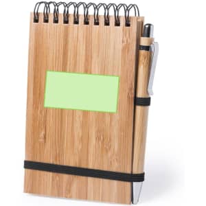 A bamboo notebook with a spiral binding, featuring a pen and a blank green label. It has an elastic band for closure.