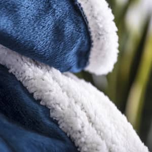 A plush navy blanket with a soft white lining, featuring a logo.
