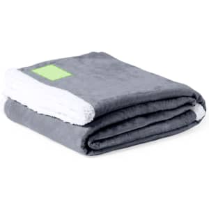 A folded grey blanket with a white underside, featuring a logo on one corner.