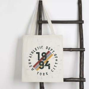 A cream tote bag with a circular graphic in green, yellow, and red, featuring a logo and the year 1994.