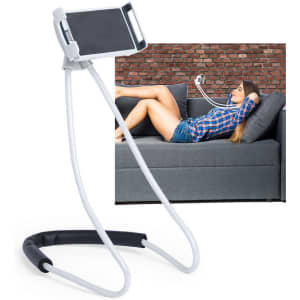 A white phone holder with flexible arms stands upright, featuring a woman relaxed on a sofa watching her phone.