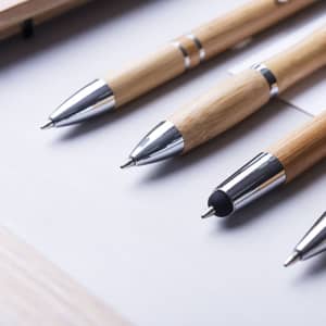 A set of wooden pens in natural bamboo with silver accents, featuring three distinct designs.