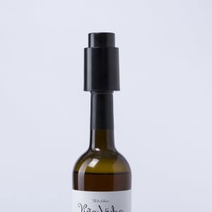 A drink bottle with a brown glass body topped by a black vacuum bottle stopper, featuring a logo.