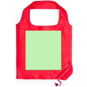 A red foldable bag featuring a square green area and a drawstring closure. It has a logo.
