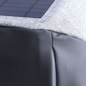 A grey backpack featuring a textured fabric design and a solar panel on the top section. It has a sleek, modern look.