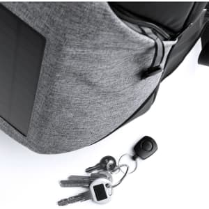A grey backpack with a solar panel, featuring a zippered pocket and a set of keys attached to it.