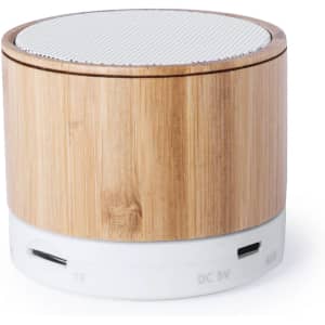 A round speaker with a bamboo exterior and a white base, featuring a mesh top. It includes various input ports.