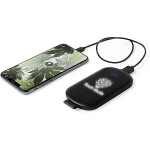 A black power bank with a logo, connected to a smartphone displaying a leafy design.