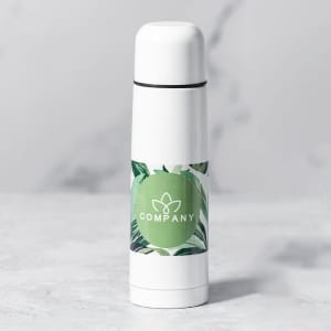 A drink bottle in white with a green label featuring a logo, decorated with a leafy design.