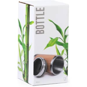 A travel mug with a stainless steel interior and a bamboo exterior, packaged in a decorative box featuring green bamboo leaves.
