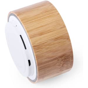 A cylindrical speaker in bamboo finish with a white circular base, featuring ports and a logo.