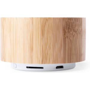 A bamboo-style speaker in natural wood tones with a white base, featuring ports for connectivity.