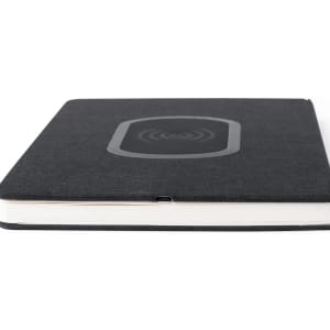 A black notepad with a wireless charging pad on the cover, featuring a fabric texture and a logo.