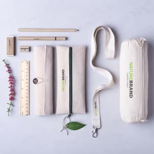 A Mirok lanyard in white alongside a pencil, ruler, eraser, and pencil cases in natural tones, with a flower.