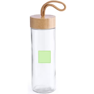 A drink bottle made of clear glass with a bamboo lid and a woven strap, featuring a blank green square.