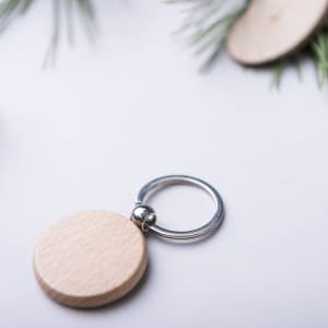 A wooden keyring with a silver metal ring, featuring a natural finish.