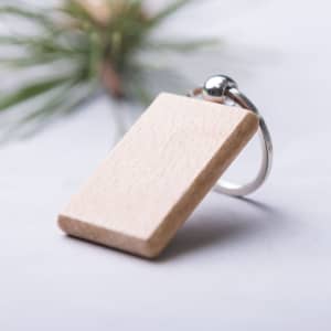 A wooden keyring with a smooth rectangular design and a metal attachment ring, featuring a natural finish.