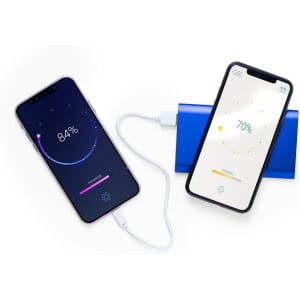A blue Tikur Power Bank with two smartphones charging, displaying battery percentage on their screens.