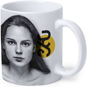 A coffee mug featuring a black and white portrait of a woman with freckles, alongside a circular graphic and logo.