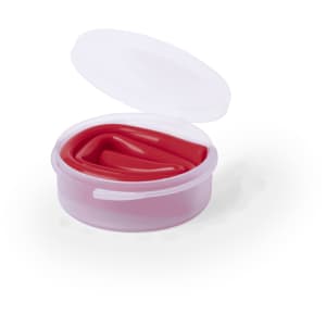 A round, clear container with a white lid, holding smooth, vibrant red product inside.