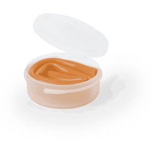 A round, transparent container with a white lid, filled with light brown product.