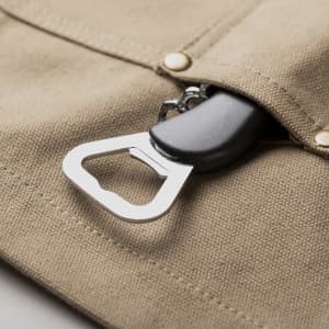 A khaki apron featuring a stainless steel bottle opener attached to an inner pocket.