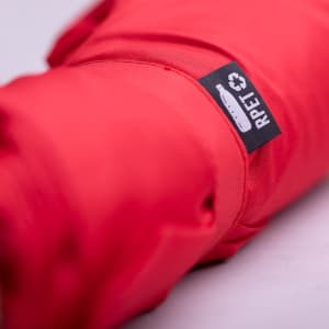 A red umbrella with a logo is rolled up, featuring a compact design for leisure and outdoor use.