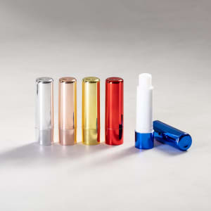A set of Tarian Lip Balms in silver, rose gold, gold, red, and blue. Each balm has a shiny, metallic finish.