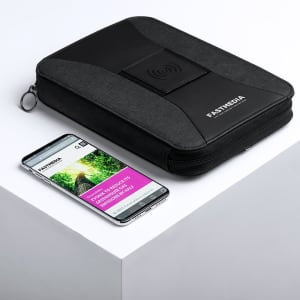 A black power bank organiser with a wireless charging pad, placed next to a smartphone on a white surface.