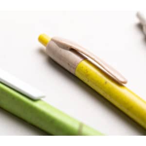 A yellow pen with a beige clip alongside a green pen and a white pen, all with branding.
