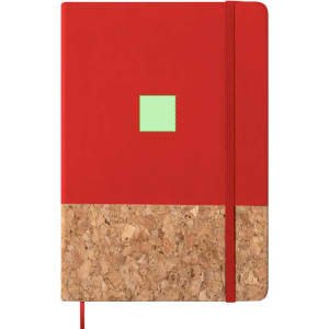 A red notepad with a cork bottom and a small green square. It features an elastic band and a logo.