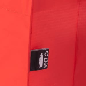 An orange reusable grocery bag features a tag indicating it’s made from recycled materials.