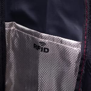 A close-up of an interior pocket featuring an RFID lining in a dark-coloured backpack, with a brand logo visible.