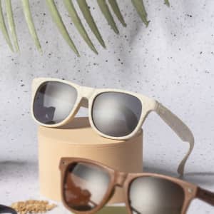 A pair of sunglasses in cream and brown shades displayed on a light background, featuring a logo.