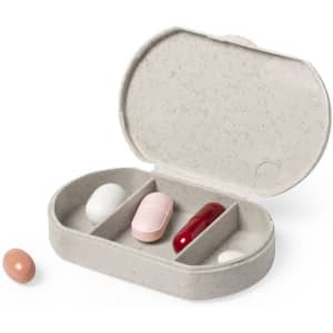 A pillbox in grey, with compartments for different tablets and capsules in pink, white, red, and brown.