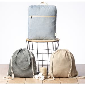 A collection of three drawstring bags in grey and beige, displayed on a wire stand with a wooden top.