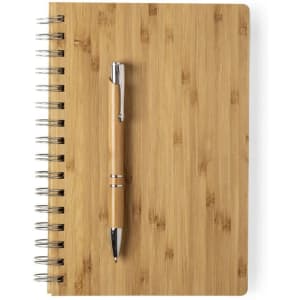 A bamboo notebook with a spiral binding and a matching wooden pen placed on top.