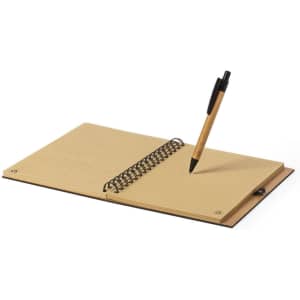 A spiral-bound notebook with lined pages and a black pen resting on top, featuring a tan cover.