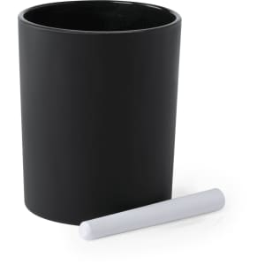 A black aromatic candle in a sleek container, accompanied by a white chalk stick.