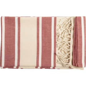 A striped towel pareo in red and cream, featuring tasselled edges and a folded design.