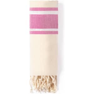 A lightweight towel pareo in cream colour with pink stripes and decorative fringes. Features a branding logo.