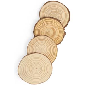 A set of four wooden coasters with natural wood grain, featuring circular designs in light and dark timber.