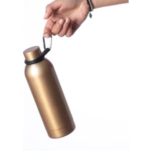 A gold drink bottle with a carabiner handle is being held by a hand.