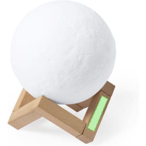 A white spherical speaker on a wooden stand with a green accent. The speaker features a minimalist design.