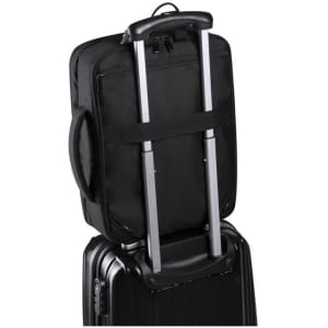 A black document bag backpack with a retractable handle, secured on top of a suitcase, featuring a logo.