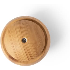 A round, wooden humidifier with a natural wood finish and a central nozzle. It features a logo on the surface.
