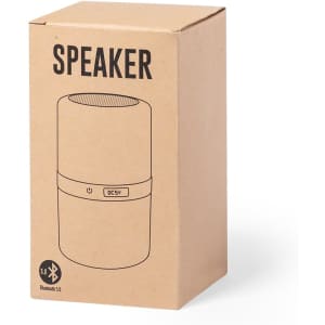 A cardboard box containing a cylindrical speaker in a neutral colour. The box features a logo and product details.