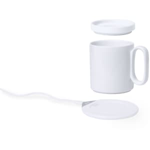 A white mug and a matching circular charger warmer, featuring a cord for power connection.